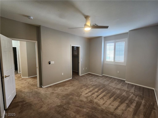 10231 Deerfield Beach Ave Unit 104, Las Vegas, NV 89129 - unfurnished bedroom featuring carpet, a walk in closet, and a ceiling fan