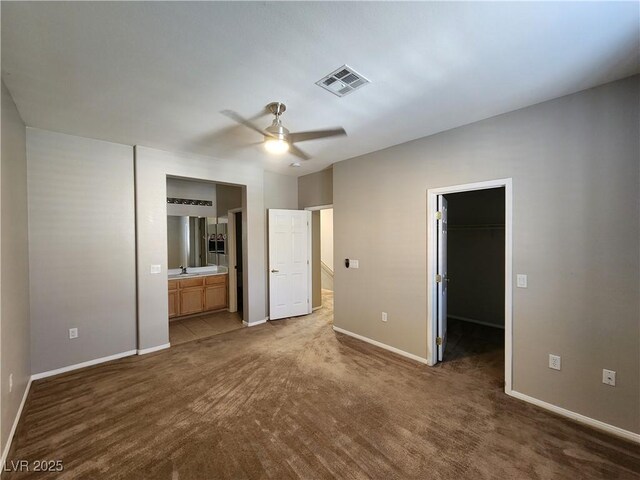 10231 Deerfield Beach Ave Unit 104, Las Vegas, NV 89129 - unfurnished bedroom featuring a spacious closet, carpet floors, ensuite bath, a closet, and a ceiling fan