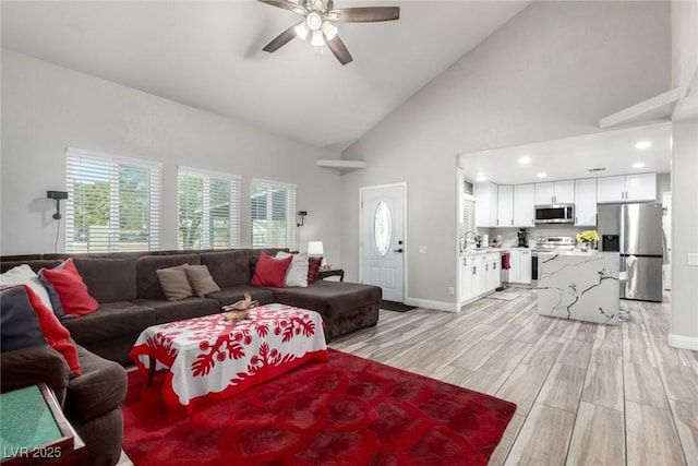 7135 Polaris Ave, Las Vegas, NV 89118 - living area featuring ceiling fan, plenty of natural light, light wood finished floors, high vaulted ceiling, and recessed lighting