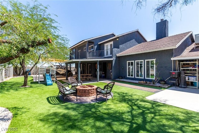 7135 Polaris Ave, Las Vegas, NV 89118 - back of house with an outdoor fire pit, a balcony, a patio, a yard, and a chimney