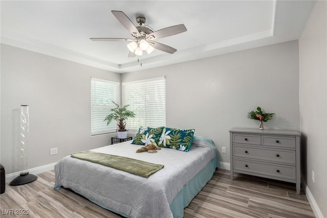7135 Polaris Ave, Las Vegas, NV 89118 - bedroom featuring a tray ceiling, light wood finished floors, and ceiling fan