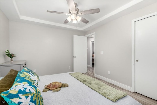 7135 Polaris Ave, Las Vegas, NV 89118 - bedroom featuring a raised ceiling, a ceiling fan, and wood finished floors