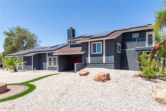 7135 Polaris Ave, Las Vegas, NV 89118 - view of front facade with solar panels, a chimney, a balcony, and a sunroom