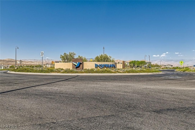 3194 Lumassina Way, Henderson, NV 89044 - view of asphalt road featuring curbs, traffic signs, street lights, and a mountain view