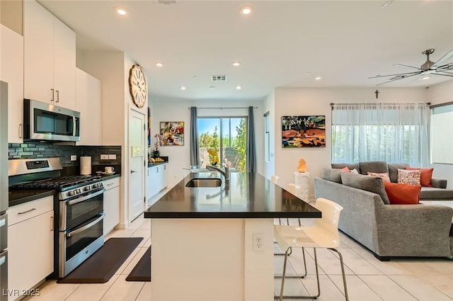 3194 Lumassina Way, Henderson, NV 89044 - kitchen featuring stainless steel appliances, open floor plan, dark countertops, light tile patterned floors, and recessed lighting