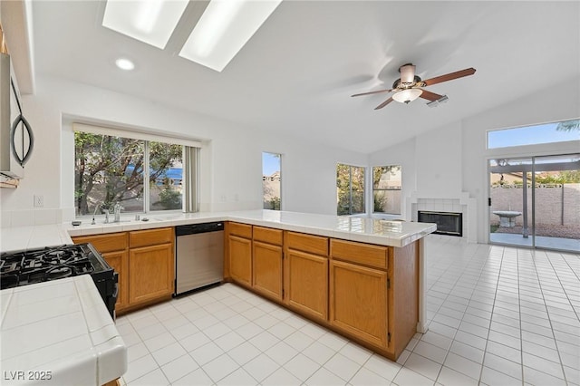 1908 Summit Pointe Dr, Las Vegas, NV 89117 - kitchen with stainless steel appliances, vaulted ceiling, tile counters, a peninsula, and healthy amount of natural light