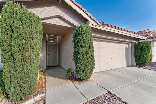 1908 Summit Pointe Dr, Las Vegas, NV 89117 - property entrance with stucco siding, a tile roof, a garage, and concrete driveway
