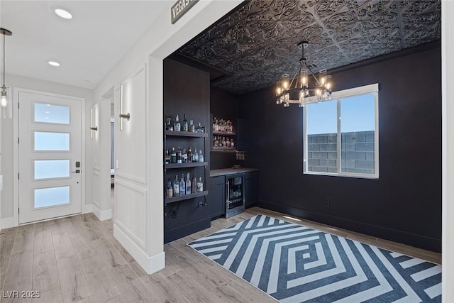 9617 Sard Ln, Las Vegas, NV 89143 - indoor dry bar with wine cooler, a chandelier, wood finished floors, decorative light fixtures, and recessed lighting