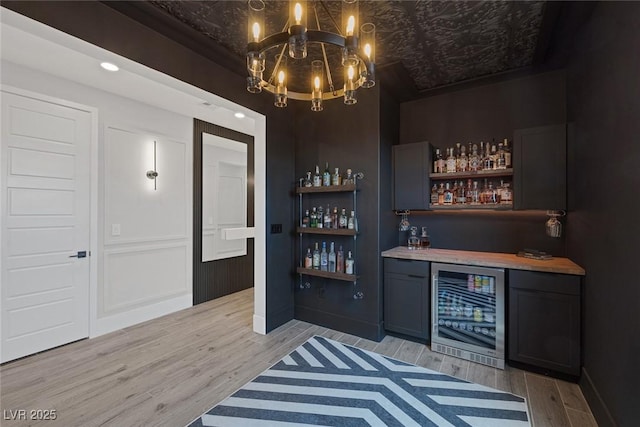 9617 Sard Ln, Las Vegas, NV 89143 - indoor dry bar with wine cooler, a chandelier, and light wood finished floors
