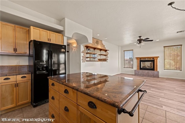 920 Vista Del Sol Ct, Mesquite, NV 89027 - kitchen featuring black fridge with ice dispenser, a kitchen island, ceiling fan, light tile patterned floors, and open floor plan
