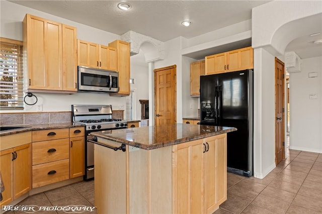 920 Vista Del Sol Ct, Mesquite, NV 89027 - kitchen with stainless steel appliances, light brown cabinets, tile patterned flooring, a kitchen island, and recessed lighting