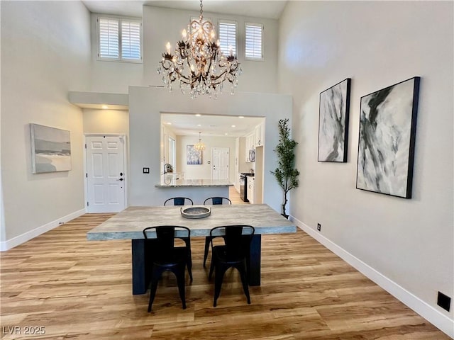 4963 Crooked Stick Way, Las Vegas, NV 89113 - dining area featuring a chandelier, a high ceiling, healthy amount of natural light, and light wood-style floors