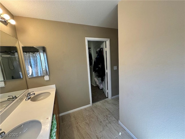 9148 Patrick Henry Ave, Las Vegas, NV 89149 - full bath with double vanity, a walk in closet, and a textured ceiling
