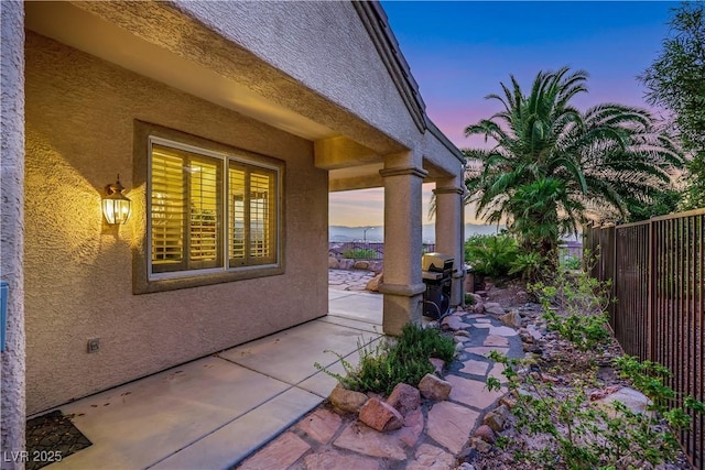 1637 Wellington Springs Ave, Henderson, NV 89052 - property exterior at dusk with stucco siding and a patio