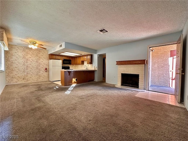 4140 Gannet Cir Unit 251, Las Vegas, NV 89103 - unfurnished living room featuring light carpet, a ceiling fan, a brick fireplace, a textured ceiling, and wallpapered walls