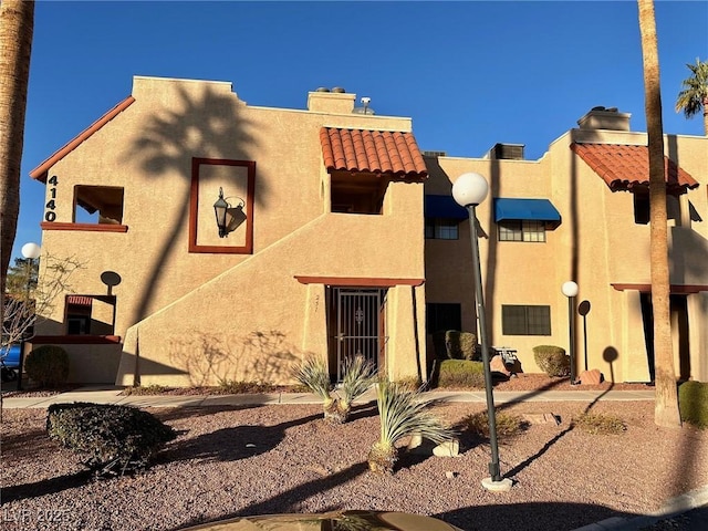4140 Gannet Cir Unit 251, Las Vegas, NV 89103 - view of front facade with stucco siding, a chimney, and a tiled roof