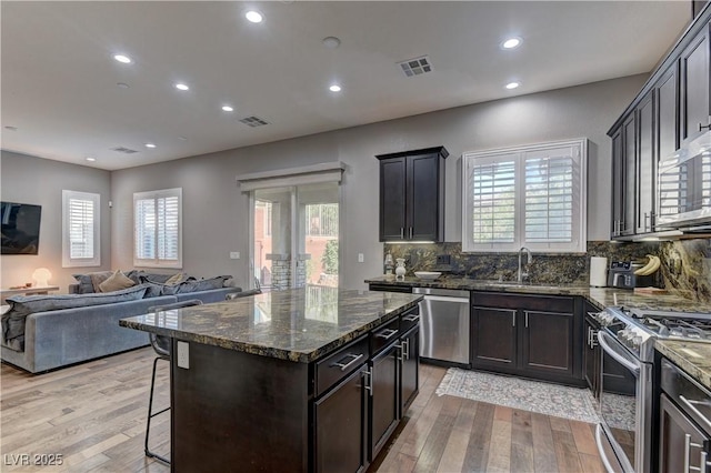 10360 Pescado Ln, Las Vegas, NV 89135 - kitchen featuring appliances with stainless steel finishes, open floor plan, light wood-style floors, recessed lighting, and a breakfast bar