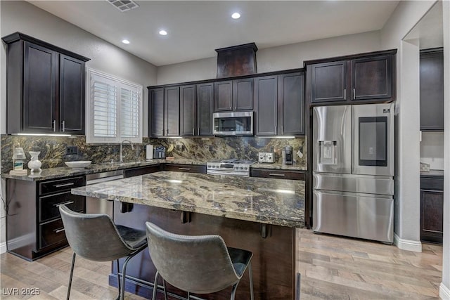 10360 Pescado Ln, Las Vegas, NV 89135 - kitchen with appliances with stainless steel finishes, stone countertops, light wood-style flooring, backsplash, and recessed lighting