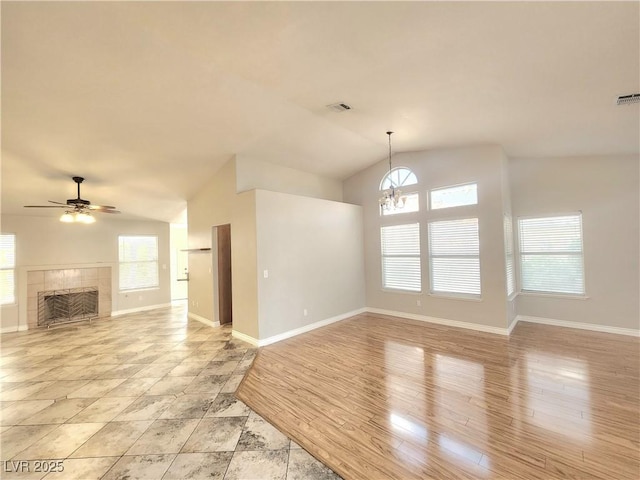 8220 Desert Beach Dr, Las Vegas, NV 89128 - unfurnished living room featuring lofted ceiling, plenty of natural light, a chandelier, ceiling fan, and a tile fireplace