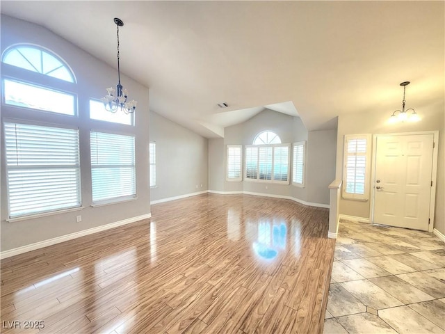 8220 Desert Beach Dr, Las Vegas, NV 89128 - unfurnished living room with a chandelier, vaulted ceiling, and light wood finished floors