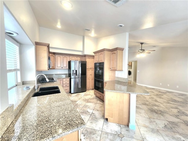 8220 Desert Beach Dr, Las Vegas, NV 89128 - kitchen featuring appliances with stainless steel finishes, a peninsula, light stone counters, ceiling fan, and washer / clothes dryer
