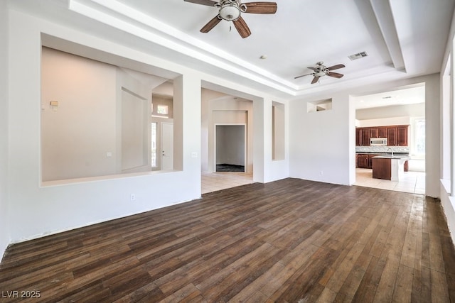 6821 Sleepy Pine St, Las Vegas, NV 89130 - unfurnished living room featuring a tray ceiling, a ceiling fan, and hardwood / wood-style floors