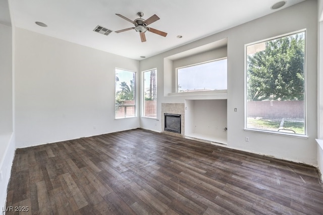 6821 Sleepy Pine St, Las Vegas, NV 89130 - unfurnished living room featuring a ceiling fan, a tiled fireplace, and dark wood finished floors