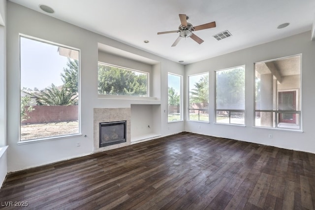6821 Sleepy Pine St, Las Vegas, NV 89130 - unfurnished living room featuring ceiling fan, plenty of natural light, dark wood-style floors, and a tiled fireplace
