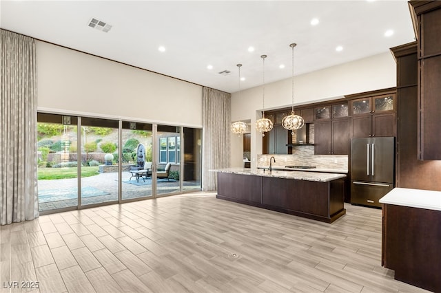 10179 Emerald Sunset Ct, Las Vegas, NV 89148 - kitchen featuring appliances with stainless steel finishes, a towering ceiling, recessed lighting, backsplash, and dark brown cabinets