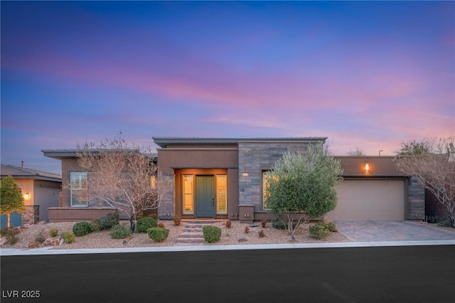 10179 Emerald Sunset Ct, Las Vegas, NV 89148 - contemporary home with stone siding, driveway, an attached garage, and stucco siding