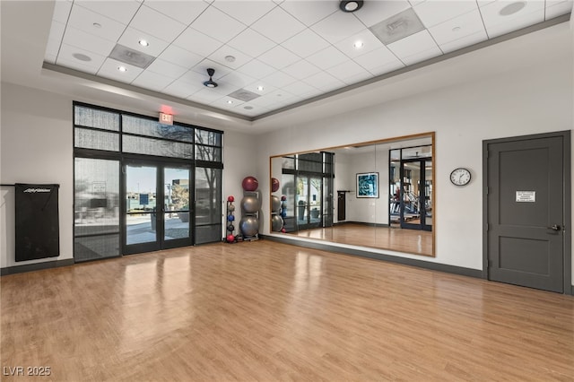 10179 Emerald Sunset Ct, Las Vegas, NV 89148 - workout room featuring wood finished floors, a tray ceiling, a paneled ceiling, and a towering ceiling