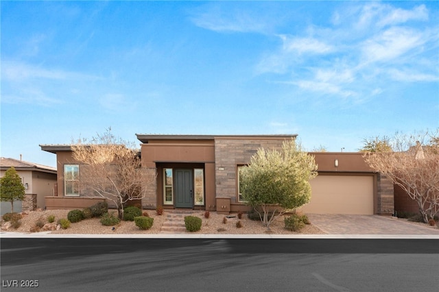 10179 Emerald Sunset Ct, Las Vegas, NV 89148 - pueblo revival-style home featuring decorative driveway, stucco siding, an attached garage, and stone siding