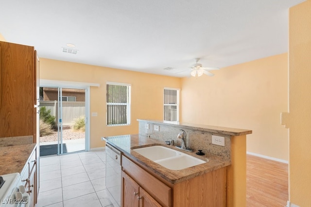 8448 Quarentina Ave, Las Vegas, NV 89149 - kitchen featuring white dishwasher, ceiling fan, a center island with sink, light stone counters, and stove