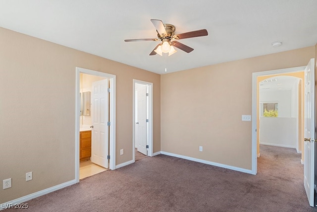 8448 Quarentina Ave, Las Vegas, NV 89149 - unfurnished bedroom with arched walkways, light carpet, ensuite bathroom, and ceiling fan