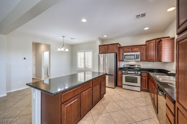 1064 Calvia St, Las Vegas, NV 89138 - kitchen featuring appliances with stainless steel finishes, light tile patterned flooring, a kitchen island, pendant lighting, and a chandelier