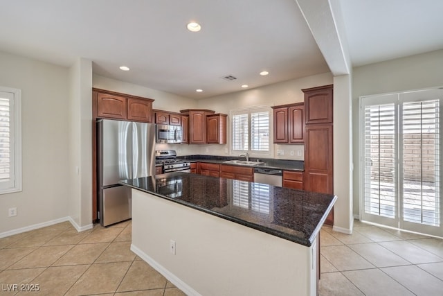 1064 Calvia St, Las Vegas, NV 89138 - kitchen with appliances with stainless steel finishes, light tile patterned floors, recessed lighting, a center island, and dark stone countertops