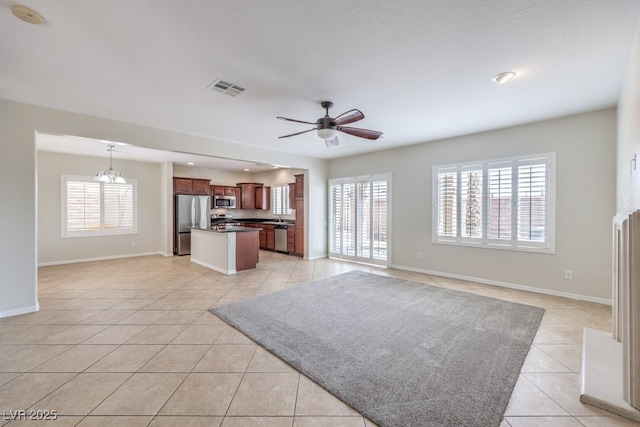 1064 Calvia St, Las Vegas, NV 89138 - unfurnished living room with light tile patterned floors, plenty of natural light, a ceiling fan, and a chandelier