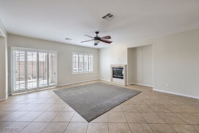1064 Calvia St, Las Vegas, NV 89138 - unfurnished living room with a ceiling fan, light tile patterned flooring, and a glass covered fireplace