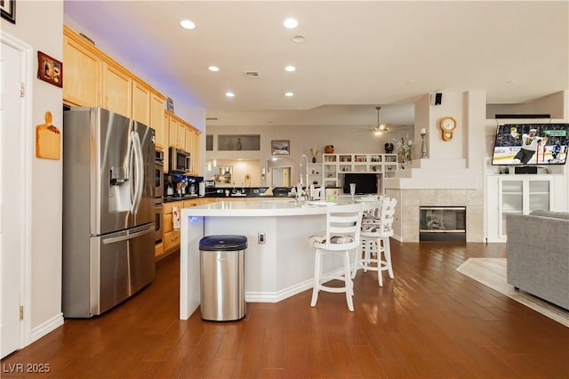 6617 Golden Bit Ave, Las Vegas, NV 89131 - kitchen with appliances with stainless steel finishes, open floor plan, light brown cabinetry, a ceiling fan, and dark wood finished floors