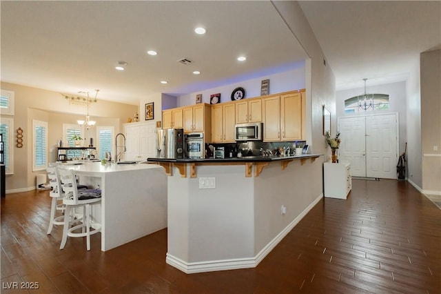 6617 Golden Bit Ave, Las Vegas, NV 89131 - kitchen featuring stainless steel appliances, a chandelier, dark wood-type flooring, a breakfast bar area, and recessed lighting