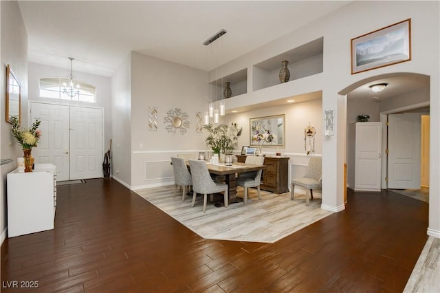 6617 Golden Bit Ave, Las Vegas, NV 89131 - dining space with arched walkways, a chandelier, wood finished floors, and a high ceiling