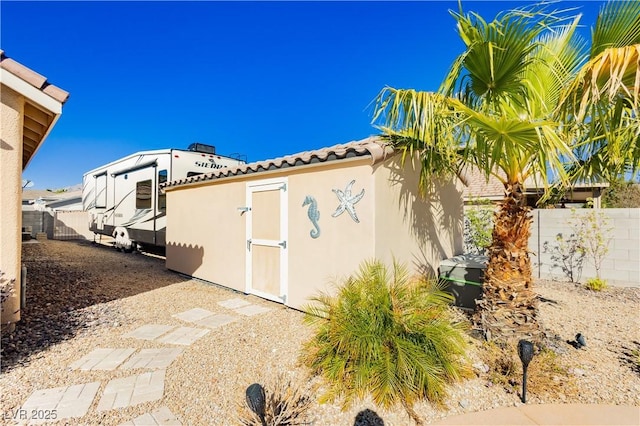 6617 Golden Bit Ave, Las Vegas, NV 89131 - view of side of home with a tiled roof, a shed, and stucco siding