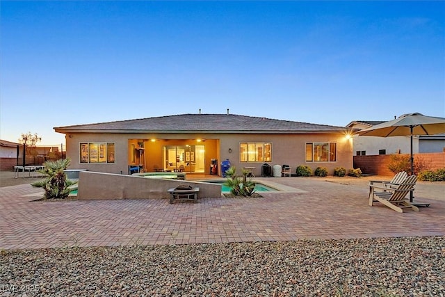 5801 Exbury Gardens Ct, Las Vegas, NV 89118 - back of property with a patio, stucco siding, and a pool with connected hot tub