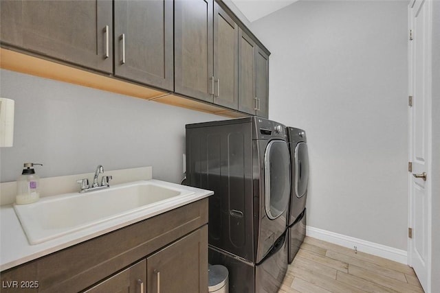 5801 Exbury Gardens Ct, Las Vegas, NV 89118 - laundry area with washing machine and clothes dryer, cabinet space, and light wood finished floors