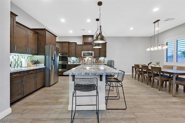 5801 Exbury Gardens Ct, Las Vegas, NV 89118 - kitchen with appliances with stainless steel finishes, light wood-type flooring, dark brown cabinetry, tasteful backsplash, and recessed lighting