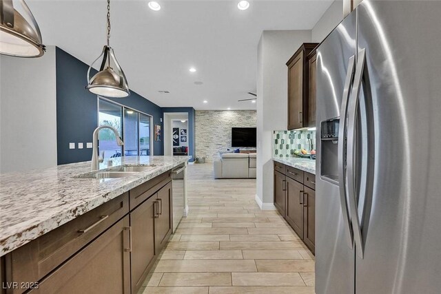 5801 Exbury Gardens Ct, Las Vegas, NV 89118 - kitchen with appliances with stainless steel finishes, dark brown cabinets, light stone counters, light wood-type flooring, and open floor plan