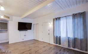 4831 Vermont Ave, Las Vegas, NV 89107 - unfurnished living room with wood finished floors and a wooden ceiling with exposed beams