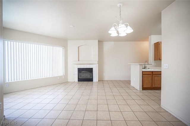 7155 S Durango Dr Unit 205, Las Vegas, NV 89113 - unfurnished living room featuring a chandelier, light tile patterned flooring, and a tiled fireplace