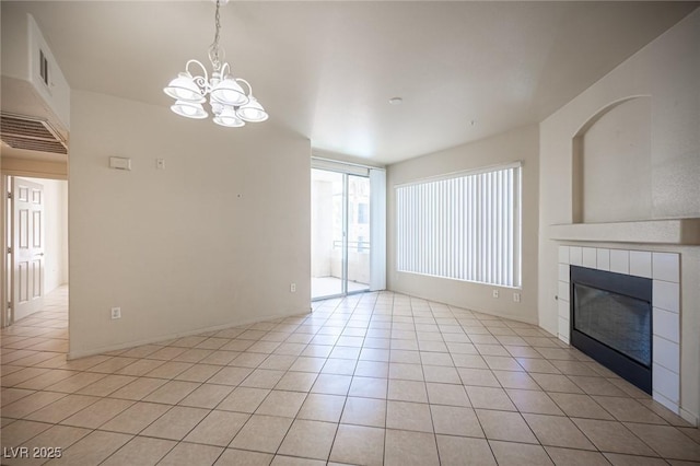 7155 S Durango Dr Unit 205, Las Vegas, NV 89113 - unfurnished living room featuring a chandelier, a tiled fireplace, and light tile patterned floors
