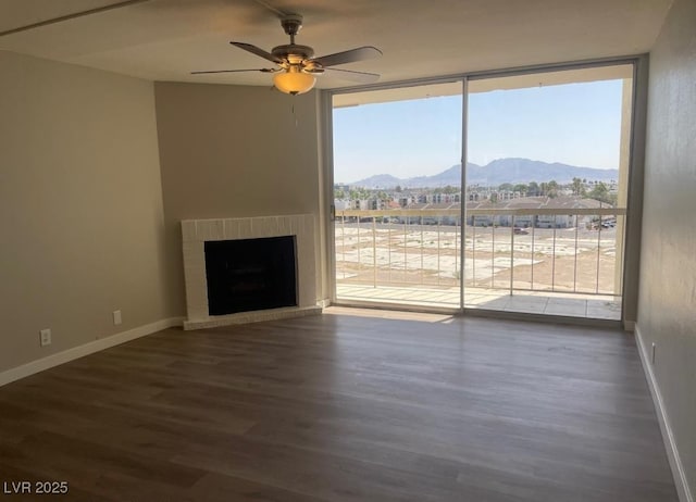 745 N Royal Crest Cir Unit 157, Las Vegas, NV 89169 - unfurnished living room with floor to ceiling windows, a mountain view, wood finished floors, a fireplace, and ceiling fan